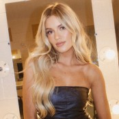A woman with long blonde hair wearing a strapless black leather top